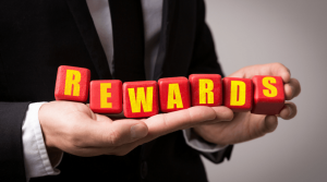 Man holding letter blocks spelling "Reward"